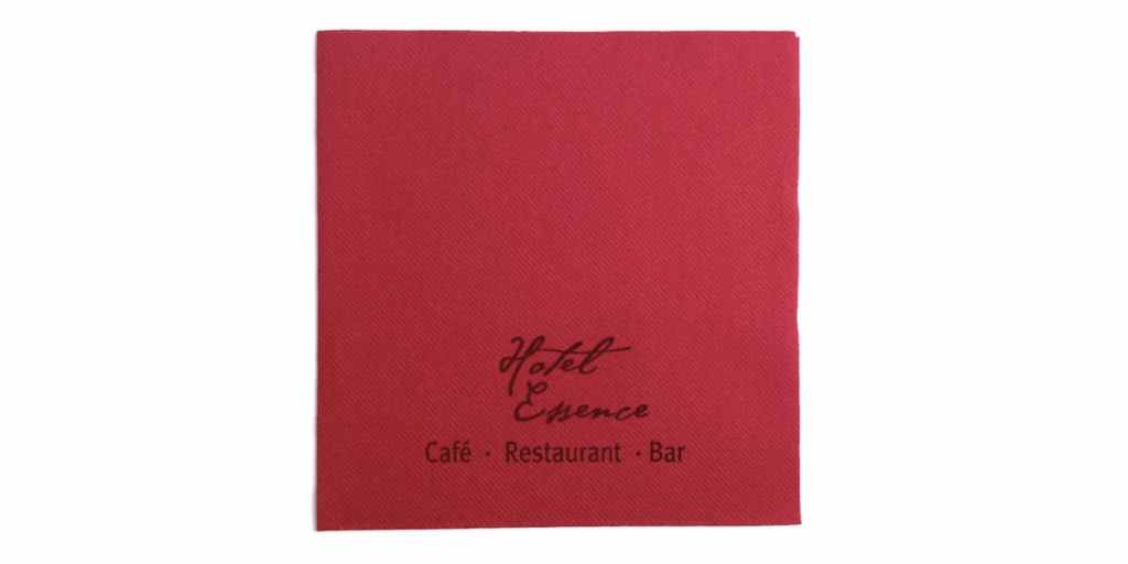 Rote, personalisierte Airlaid-Serviette mit schwarzem Logoaufdruck „Hotel Essence“ sowie den Worten „Café · Restaurant · Bar“. Stilvolles, hochwertiges Design für Gastronomie und Hotellerie mit eleganter Markenpräsentation.